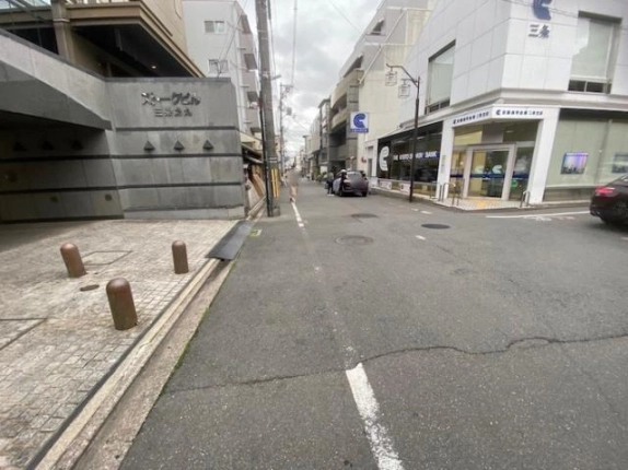 三条通を反対方向に見た周辺の様子。左手にストークビル三条烏丸の館名表示と入口前の石畳