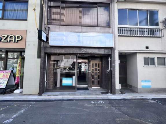 バー居抜き店舗の正面外観。ガラス扉と右側の格子模様の入口