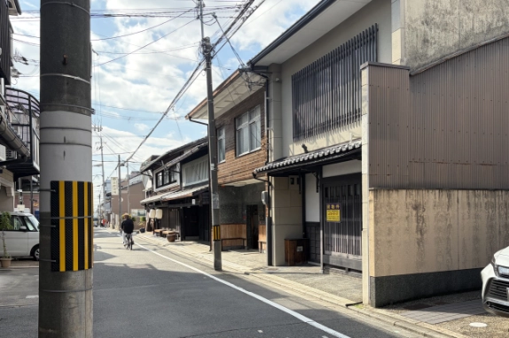 大宮通の歩道から見た通りの奥へ続く町家の街並み。右手に格子戸と貸物件看板のある京町家テナントがある