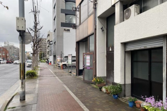 西大路通沿いの前面歩道。右手に物件の入口と隣接建物、左手に車道