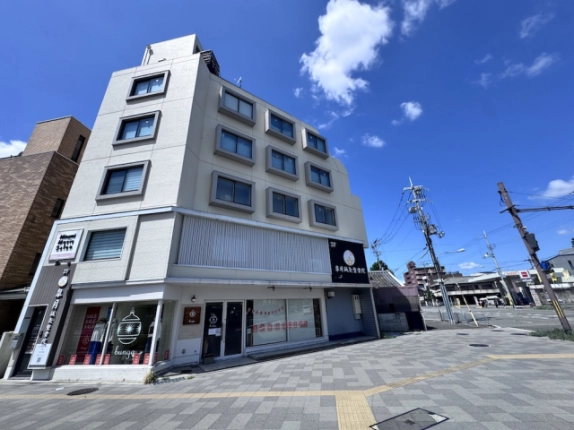 五条七本松交差点に立つ建物の全景。角を挟んだ二面の窓と1階のガラス面