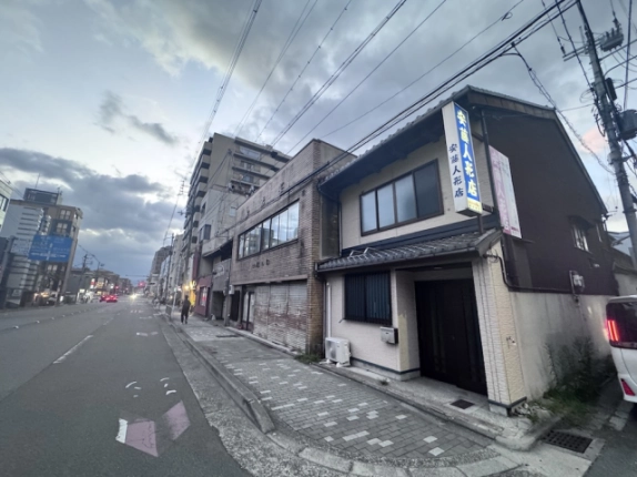 米屋町の京町家店舗と隣接する建物。角度をつけて見た正面と濃い色の側壁