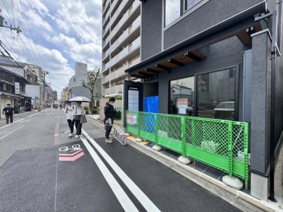 建物1階部分を近くから見た外観。ひさしの下の窓と出入口、前面道路との位置関係