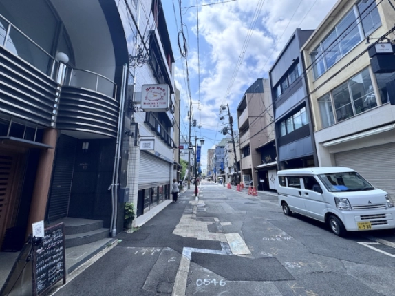 寺町二条店舗前から見た道路。左手に金属の横格子がある外壁と入口の段差