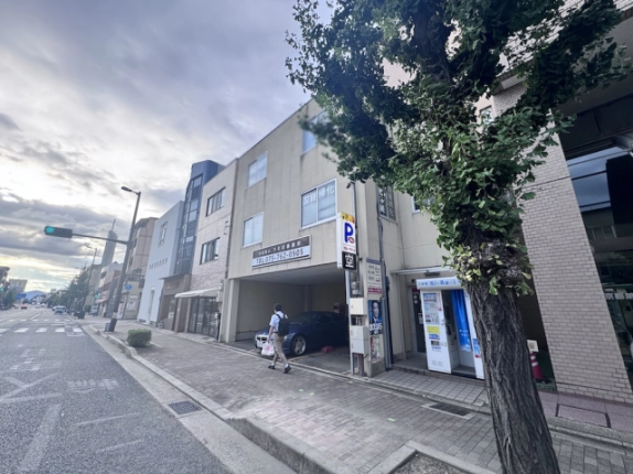 神宮丸太町駅徒歩4分の物件周辺。右手に上田ビルと街路樹、奥に交差点が見える丸太町通