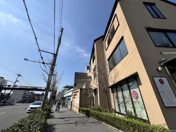 2階に貸事務所がある伊佐ビルを見上げた外観。道路に面した横長の窓と建物沿いの植え込み