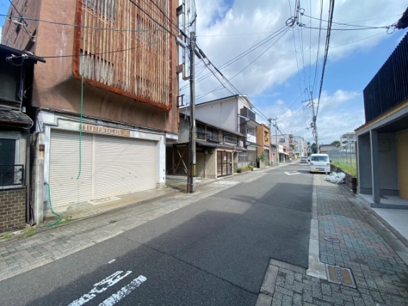 東堅町の店舗を左手奥に見た前面道路。沿道に並ぶ建物