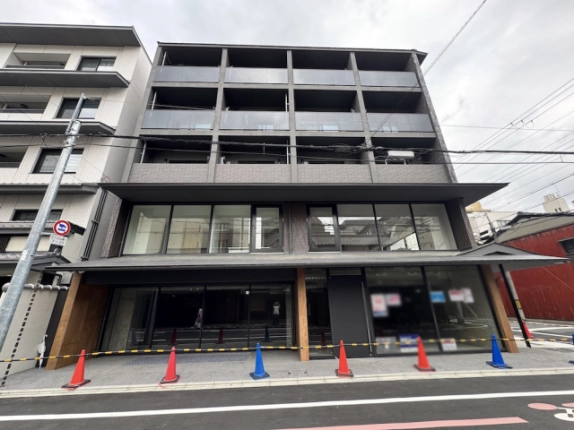 建物を正面から見上げた外観。格子状に並ぶバルコニーと横に連なる窓
