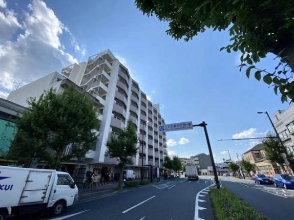 松ヶ崎駅周辺の建物全景と北大路通。道路に沿って続くバルコニーと街路樹