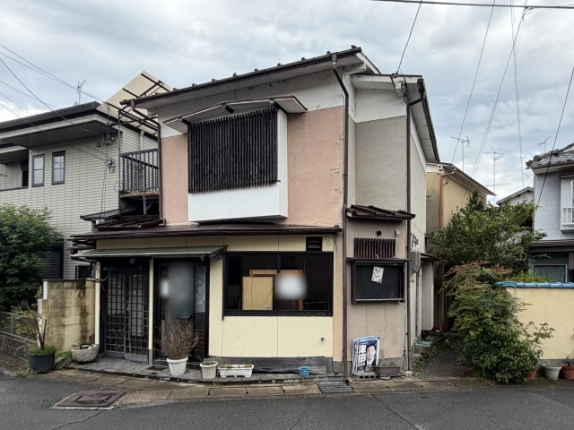 正面の近景。1階の格子戸と内側に板が見える窓、2階の木製格子窓、右側の小窓と掲示板