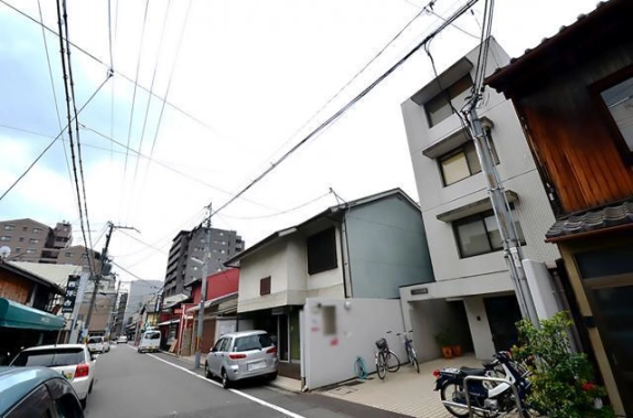 建物を右手に見た反対方向の室町通。白い正面外壁と隣接する町家