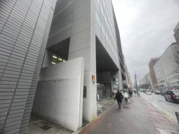 インターワンプレイス烏丸IIの入口付近を反対側から見た外観。タイル張りの壁と歩道