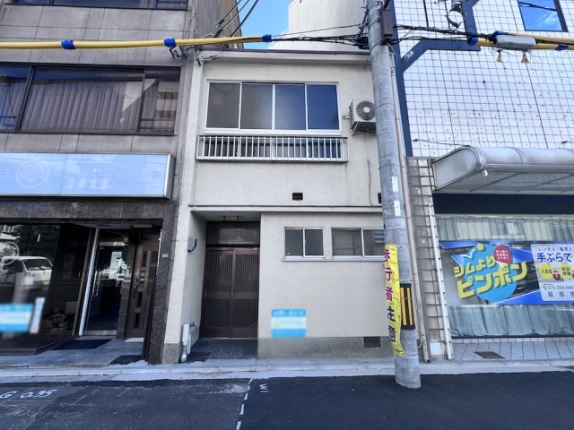 壬生馬場町一棟店舗の正面外観。1階の入口と小窓、2階窓の手すり
