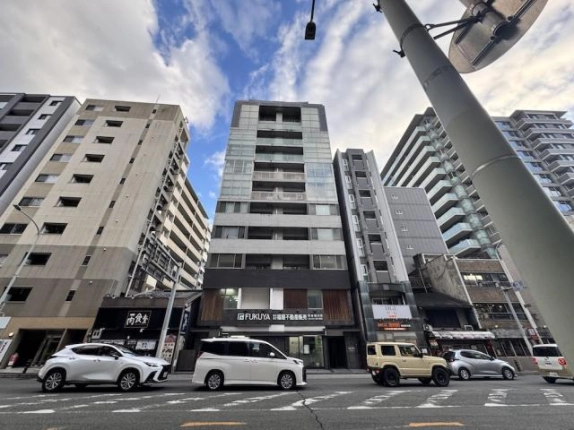 2階に店舗区画があるクオン四条柏屋町の全景。白と黒の外壁と上下に連なるバルコニー