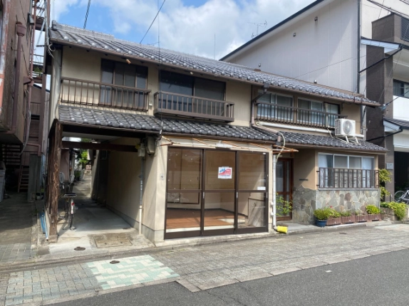 京都市上京区東堅町の戸建店舗外観。瓦屋根と1階のガラス引き戸、左側の通路