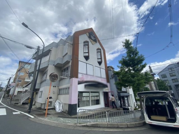 佛教大学前の角地に立つ建物を斜めから見た様子。縦長の窓と二方向の道路