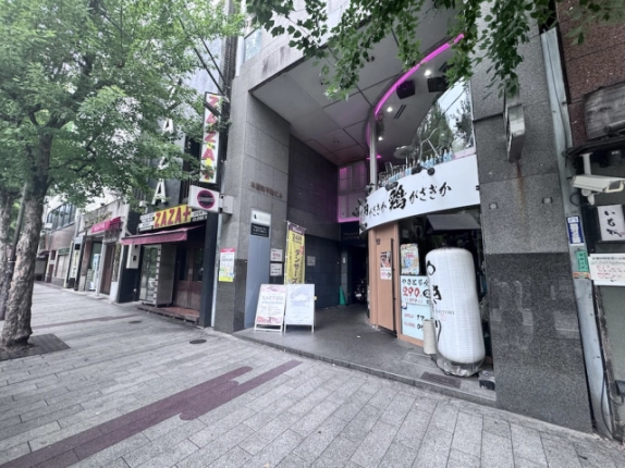 302号室が募集区画の木屋町不動ビル。斜めから見た共用入口と歩道沿いの店舗