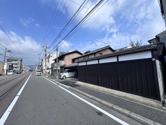 山ノ内宮前町の京町家と前面道路。右手に長く続く板塀と左手の軌道