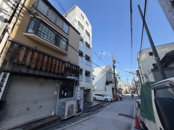 Casa La Vitaを左手に見た前面道路。隣接する低層建物と奥へ続く街並み