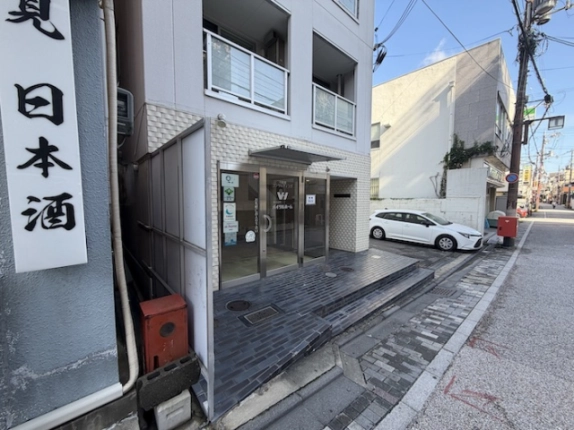 中書島駅徒歩1分の1階貸店舗入口。ガラス扉と黒いタイルの段差、建物前の道路