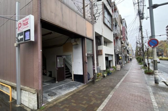 建物1階の開口部と奥に見える階段。入口前から右奥へ続く歩道