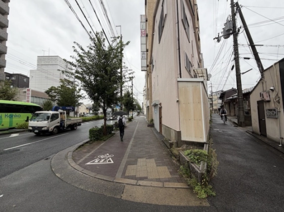 西尾ビル（仮）の角から見た周辺道路。左手の大通り沿いの歩道と右手の細い通り