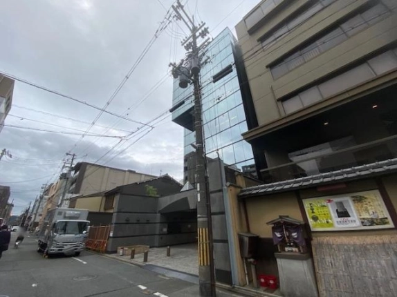 烏丸御池駅徒歩5分の貸事務所が入る建物。斜めから見たガラスの外壁と前面道路
