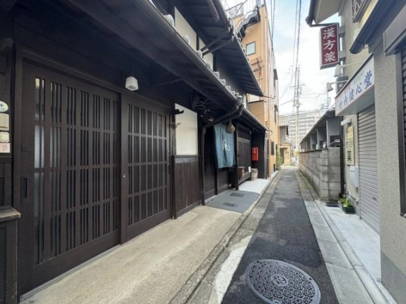 京都駅徒歩8分の一棟貸店舗事務所を左手に見た路地。町家の軒先と奥へ続く通路