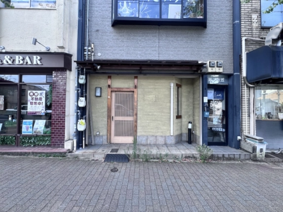 衣笠第7ビル1階の店舗正面。淡い色の壁と木製格子戸、右端の縦長窓