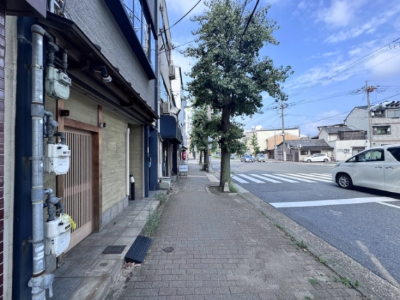 衣笠第7ビルを左手に見た今出川通。店舗前の歩道と右奥の横断歩道